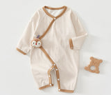 Striped baby romper with brown accents and a matching toy on a white background
